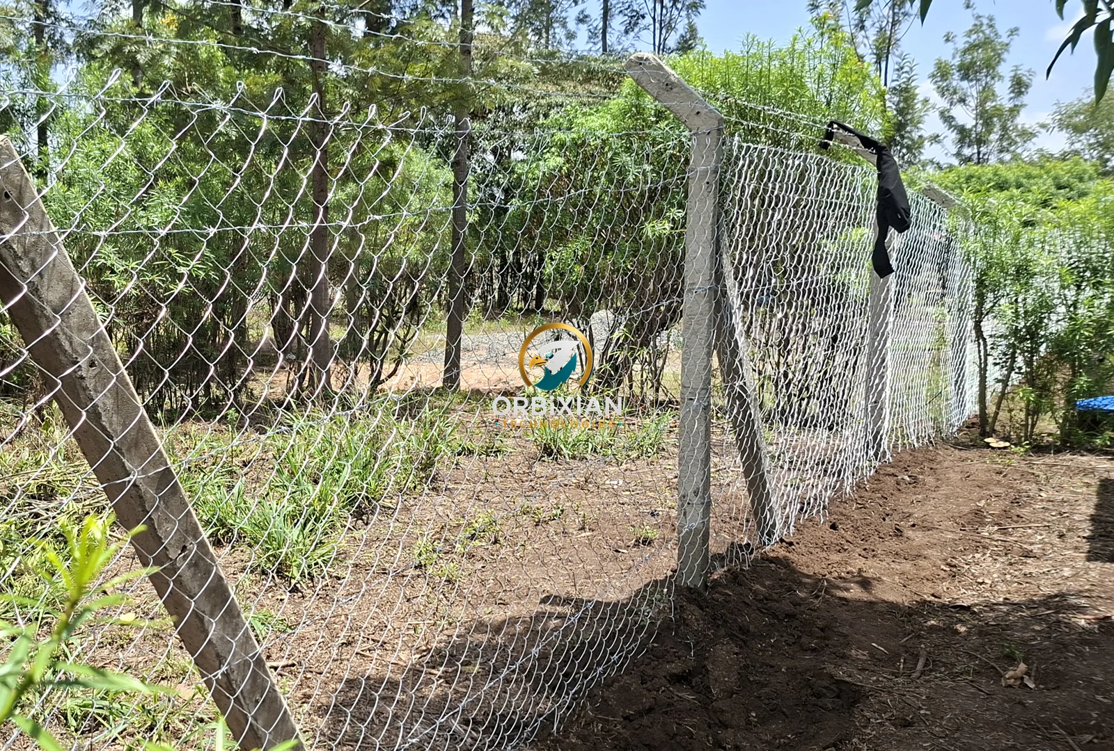Concrete strainer supporting galvanized chainlink fence and barbed wire in Kirinyaga
